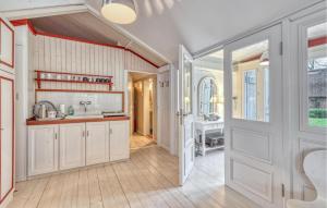 eine Küche mit weißen Schränken und einer offenen Tür in der Unterkunft Gorgeous Home In Galmsbüll in Galmsbüll