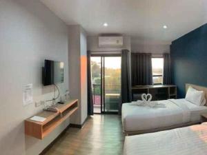 Ban Na KhwaiにあるTripper Hotelのベッド2台とテレビがあるホテルの部屋