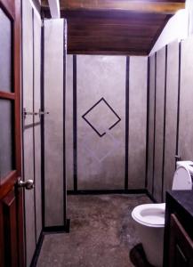 ein Bad mit einer Tür und einem WC in der Unterkunft K siri Holiday Home in Balapitiya