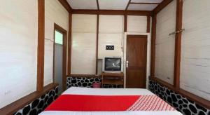 Habitación con cama y TV. en OYO 93277 Villa Kemiloko Syariah, en Prigen 41 fotos más