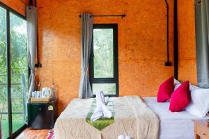 1 Schlafzimmer mit 2 Betten mit roten Kissen und einem Fenster in der Unterkunft ภูธาราทรีเฮาส์แอทเชี่ยวหลาน Phutara Treehouses At Cheowlan in Ban Pha Saeng Lang