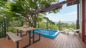a patio with a table and a swimming pool at Boryeong Thirasel Pension in Boryeong