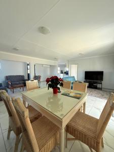 a living room with a dining table and chairs at Corner Rock in Stompneusbaai +9 photos