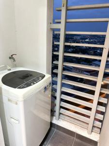 un baño junto a una ventana con lavadora en Silksky - Modern Design, Awesome City View, Free Parking, Free Netflix account, 200mbps WIFI, Privacy,, en Serdang