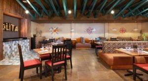 Un restaurante con mesas y sillas y un sofá. en Celuisma Playa Dorada All Inclusive, en Sampiño