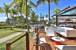 un patio con mobili bianchi e palme di Mahogany Hotel Residence & Spa a Le Gosier