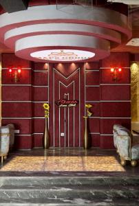 Una habitación con una pared roja con dos jarrones dorados. en Hotel Sakura Gold, en Gurgaon