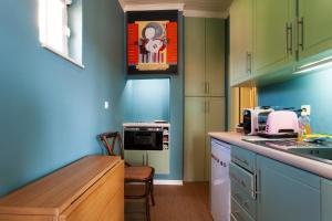 eine Küche mit blauen und grünen Wänden und einer Theke in der Unterkunft ALTIDO Trendy studio with views to the Castle, in Graca in Lissabon