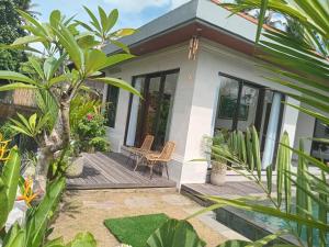 una piccola casa bianca con portico in legno di The Samudra Ubud Villa ad Ubud