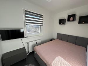 a small bedroom with a bed and a window at Appartement Märzenkeller in Murau +1 photo