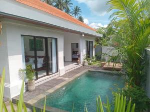 una villa con piscina di fronte a una casa di The Samudra Ubud Villa ad Ubud