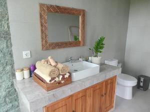 un bagno con lavandino e specchio di The Samudra Ubud Villa ad Ubud Altre 20 foto