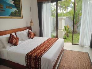 una camera da letto con un letto e una grande finestra di The Samudra Ubud Villa ad Ubud