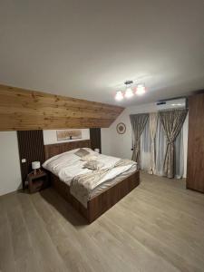 a bedroom with a large bed in a room at Vila Soleil in Azuga