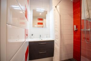 un baño con lavabo y espejo en Chambre - Dorine, en Aroue