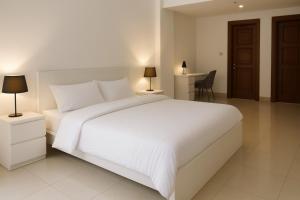 Un dormitorio con una gran cama blanca y un escritorio. en Townhouse in Golden Mile 3BR, en Dubái