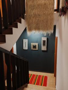 a hallway with a staircase and a blue wall with artwork at Monastery 2 Aparthotel in Pamporovo