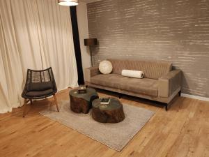 a living room with a couch and a table and a chair at Monastery 2 Aparthotel in Pamporovo