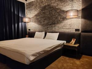 a bed in a room with a brick wall at Monastery 2 Aparthotel in Pamporovo +83 photos