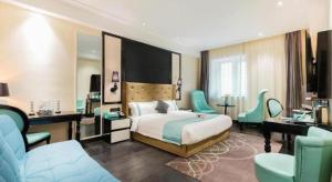 a hotel room with a bed and a desk and chairs at Xana Hotelle· Tianjin Railway Station Jinwan Square Binjiang Avenue in Tianjin