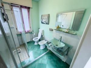 a bathroom with a toilet and a sink and a shower at Casa Vacanza TDL in Torre del Lago Puccini +26 photos