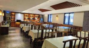 Un comedor con mesas y sillas en un restaurante. en James Joyce Coffetel Xian Dayanta Metro Station Branch, en Xi'an