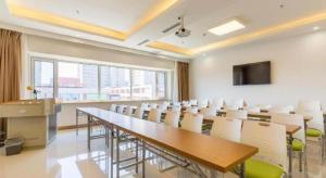 una sala de conferencias con una mesa larga y sillas en GreenTree Inn Shenyang Shenhe District Wuai Street, en Shenyang