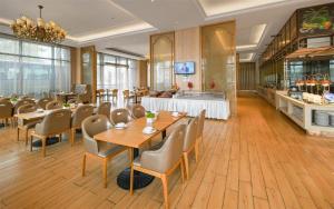 Un restaurante con mesas y sillas en una sala. en Vienna Best Sleep International Hotel Shenzhen New Airport Branch, en Baoan