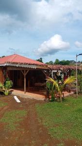 a house with a red roof and a yard at Danae Beach Golf in Nosy Be