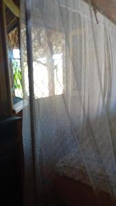 una tenda in una stanza con finestra di Danae Beach Golf a Nosy Be