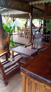 un gruppo di sedie e tavoli in legno su un patio di Danae Beach Golf a Nosy Be