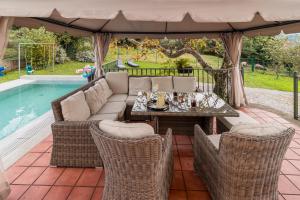 a patio with a couch and chairs and a table at Casa La Quinta in Colindres