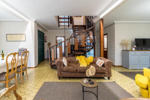 a living room with a couch and a spiral staircase at Casa La Quinta in Colindres