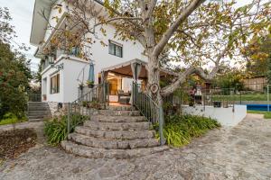 a house with stairs leading up to a tree at Casa La Quinta in Colindres