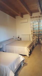 PomaricoにあるB&B Alle porte di San Roccoのベッドルーム1室(ベッド2台、窓付)