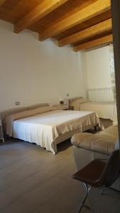 PomaricoにあるB&B Alle porte di San Roccoのベッドルーム1室(ベッド2台、椅子付)