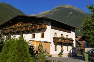 un edificio blanco con flores en las ventanas en Appartement Stuibenfallblick en Umhausen