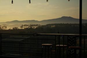 Una vista de las montañas desde un balcón con taburetes. en A La Mer Măng Đen, en Kon Plong