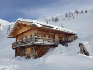 a log cabin is covered in snow at SANDALM Almhütte (2096m) in Innervillgraten