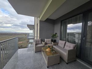 a balcony with a couch and chairs on a balcony at Green Residence Rasnov in Râşnov
