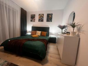 a bedroom with a bed with a green comforter at Green Residence Rasnov in Râşnov
