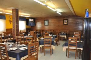 uma sala de jantar com mesas e cadeiras num restaurante em Hotel La Braña em San Isidro