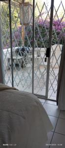 une chambre avec vue sur une table et des fleurs violettes dans l'établissement Budler Stay, à Upington