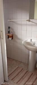 une salle de bains blanche avec un lavabo et un miroir dans l'établissement Budler Stay, à Upington