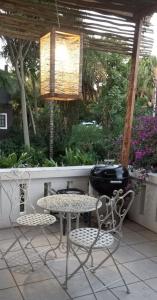 un patio avec une table, des chaises et un barbecue dans l'établissement Budler Stay, à Upington