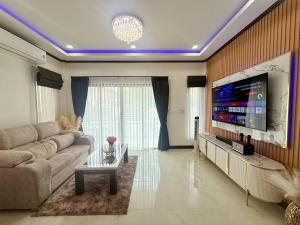 a living room with a couch and a large flat screen tv at PS House Bangtao in Bang Tao Beach