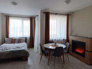 a bedroom with a bed and a table and a fireplace at Apartment B45 Borovets Gardans in Borovets