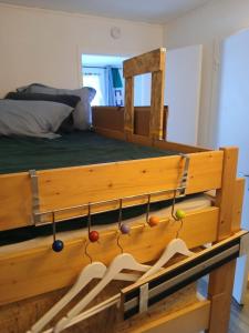 een bed met een houten bedframe met kledinghangers bij Les Chamoix en Chartreuse in Saint-Pierre-de-Chartreuse +6 foto's