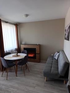a living room with a table and a couch and a fireplace at Apartment B45 Borovets Gardans in Borovets