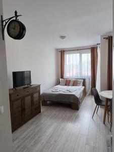 a bedroom with a bed and a clock on the wall at Apartment B45 Borovets Gardans in Borovets